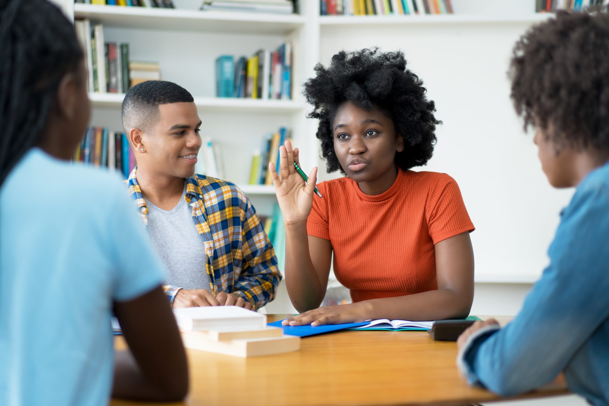 Group of talking brazilian and african american students at classroom of university